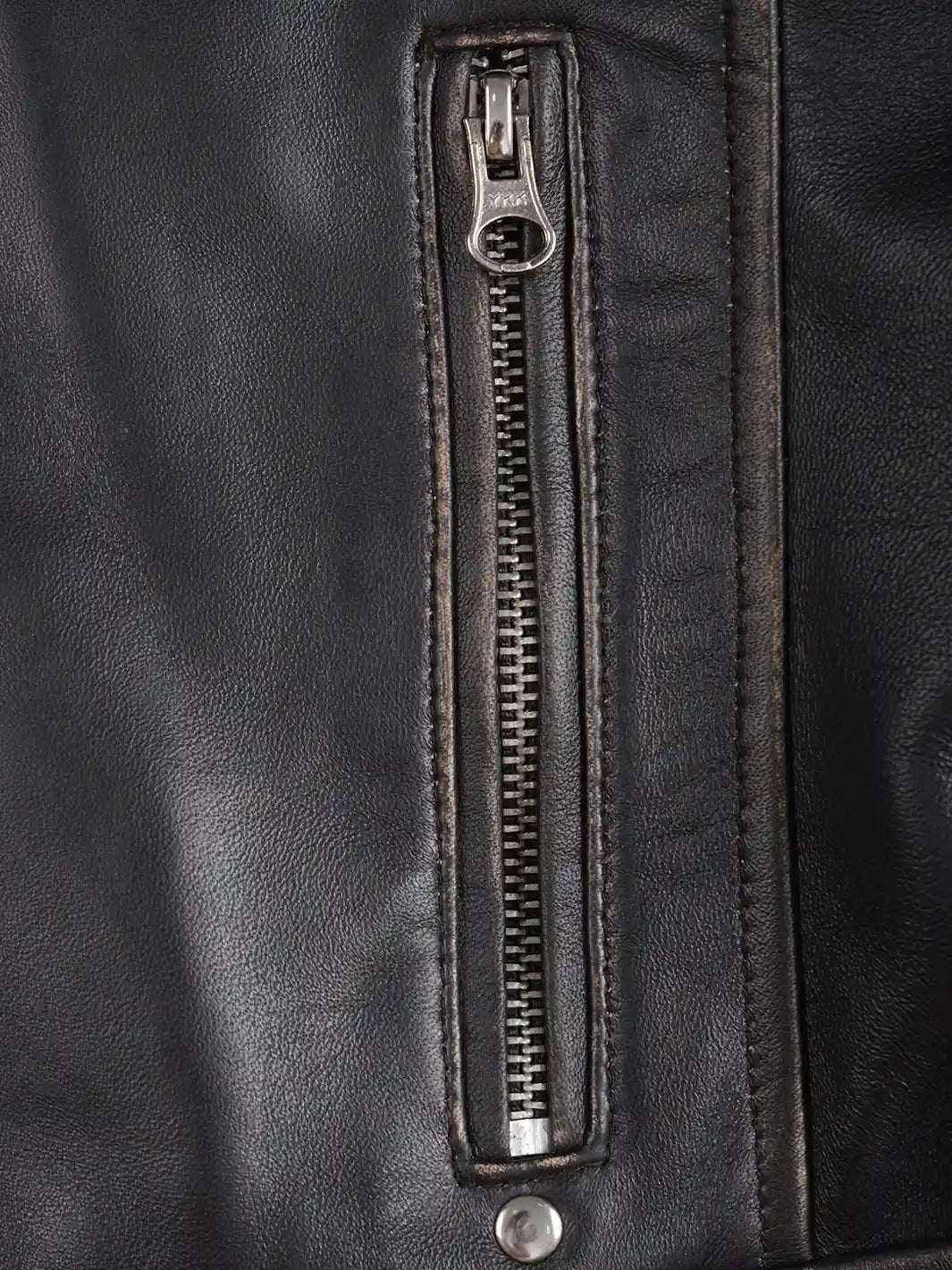 Close-up of a black leather jacket with a zipper detail